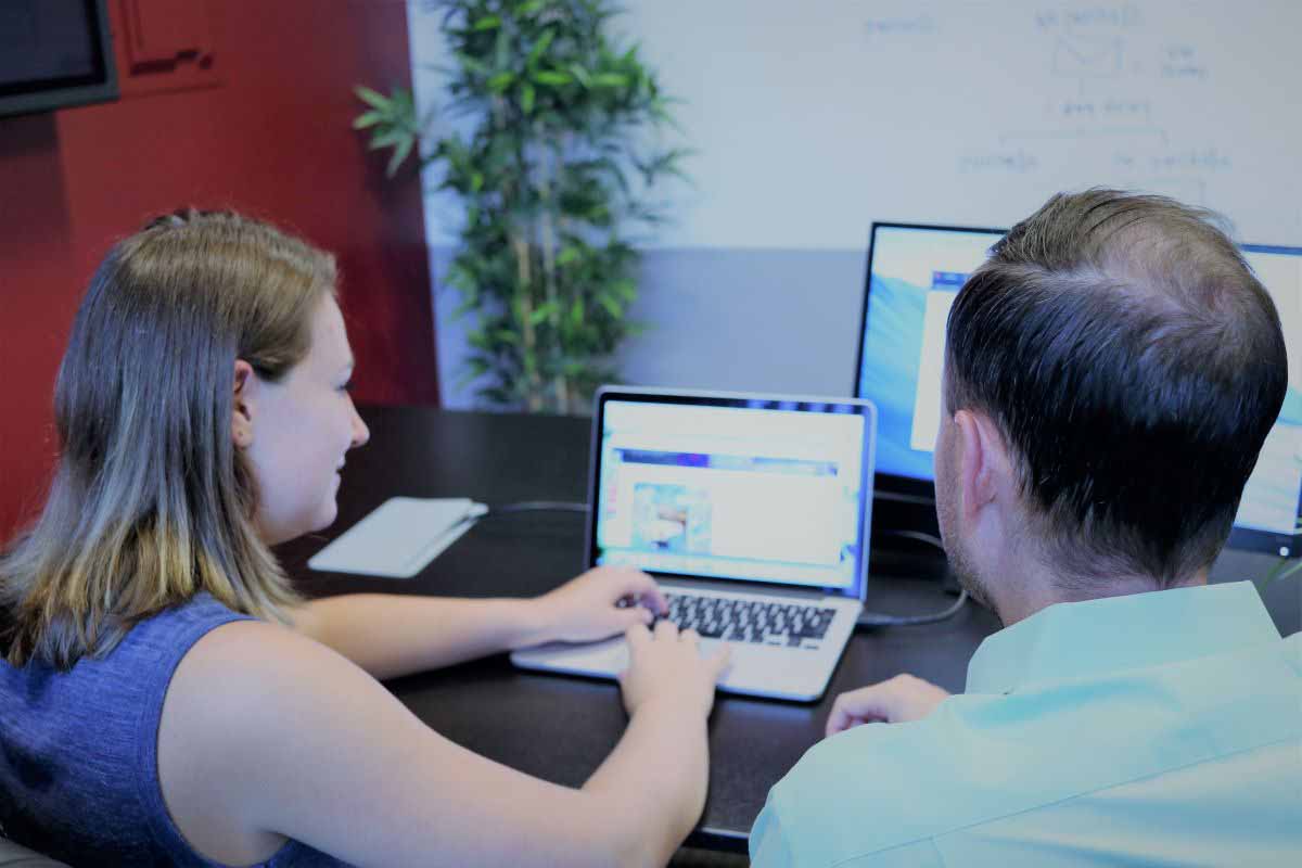 Two people in front of a laptop 